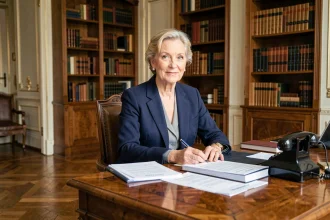 Femme d'affaires française élégante assise à un bureau parisien antique, évoquant le rôle discret mais influent d'Anne Dewavrin dans l'ascension de Bernard Arnault