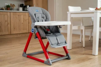 Chaise haute Chicco Polly Magic 3 en 1 en rouge et gris posée sur un parquet clair dans une cuisine familiale moderne
